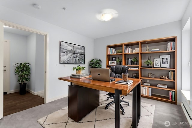 office space featuring light carpet, a baseboard radiator, and baseboards