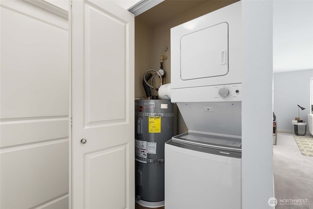 laundry room with water heater, stacked washer and dryer, and laundry area