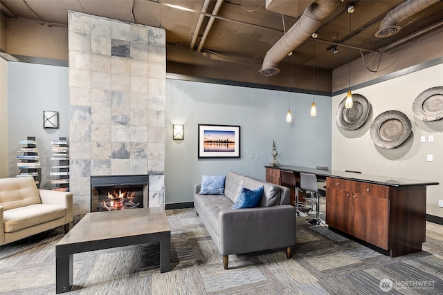 living area featuring visible vents, a fireplace, baseboards, and built in study area