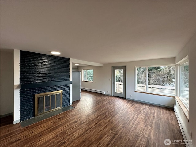 unfurnished living room with a brick fireplace, a baseboard radiator, baseboards, and wood finished floors