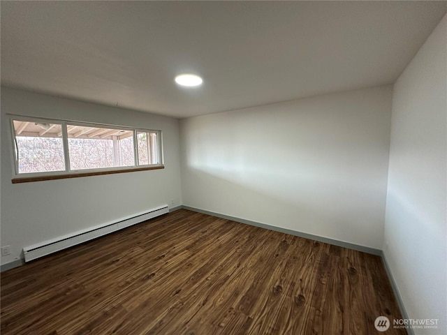 empty room featuring a baseboard radiator, dark wood finished floors, and baseboards