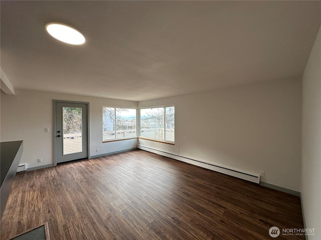 spare room with dark wood-style floors, a baseboard radiator, and baseboards