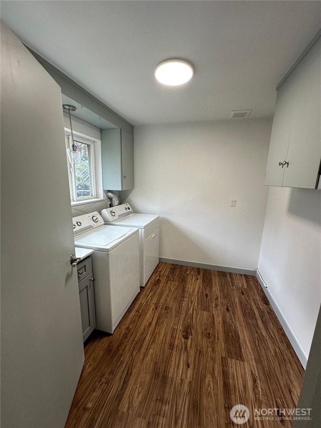 washroom featuring baseboards, dark wood-type flooring, cabinet space, and washer and dryer