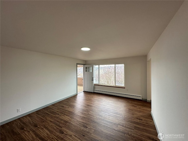 unfurnished room featuring dark wood-style floors, baseboard heating, and baseboards