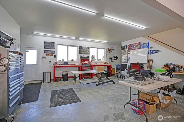 miscellaneous room featuring a workshop area and concrete floors