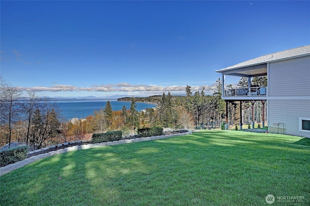 view of yard with a balcony and a water view