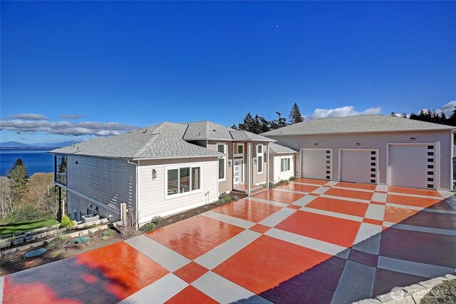 view of front of property featuring a garage and roof with shingles