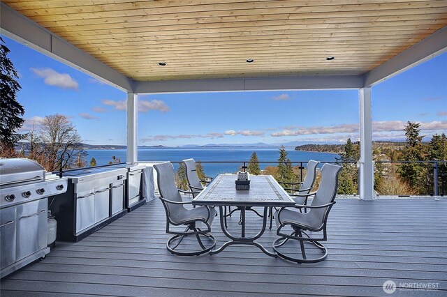 wooden deck featuring outdoor dining space and a water view