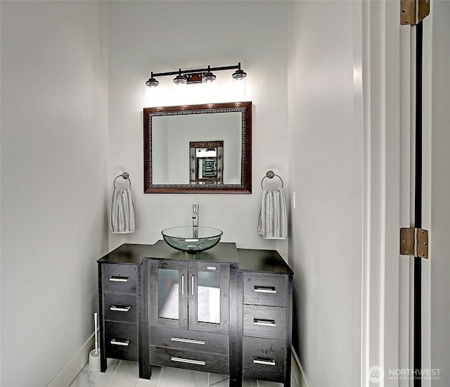 bathroom featuring marble finish floor, vanity, and baseboards