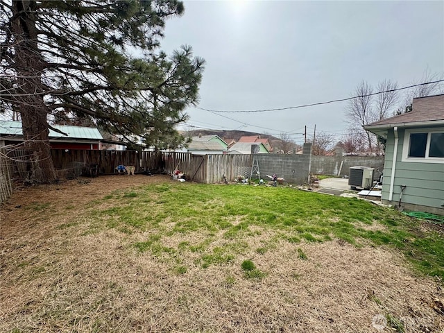 view of yard with central AC unit and a fenced backyard