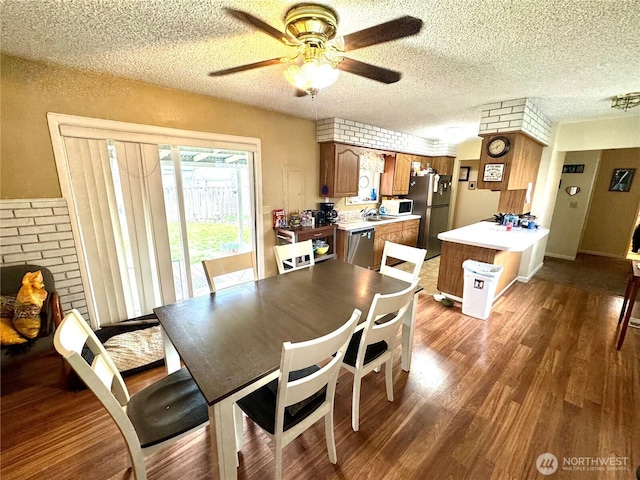 dining room featuring ceiling fan, a textured ceiling, and wood finished floors