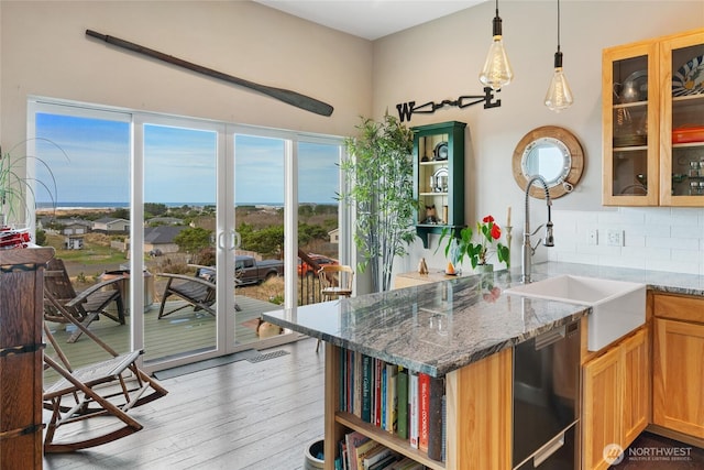 kitchen featuring open shelves, backsplash, a sink, and dishwashing machine