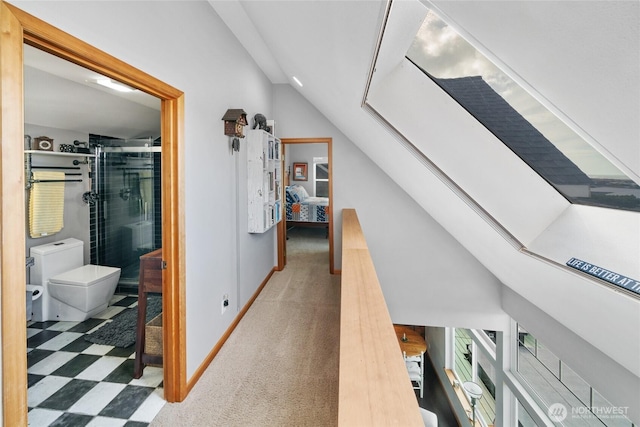 corridor featuring vaulted ceiling, carpet floors, and baseboards