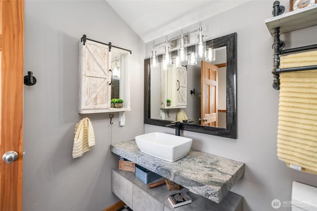 bathroom with lofted ceiling and a sink