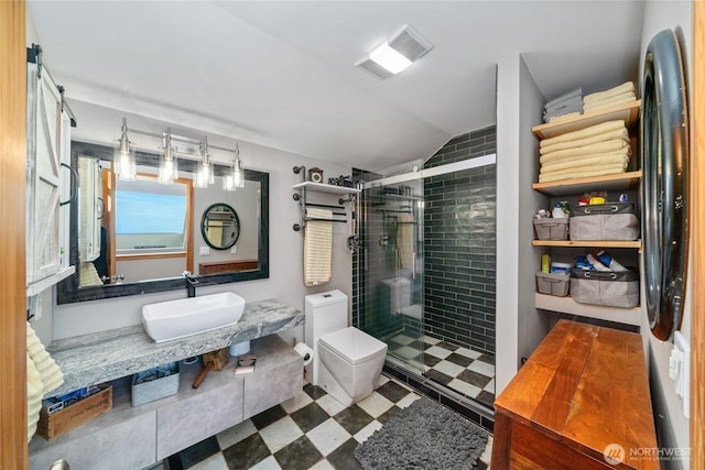 bathroom with toilet, lofted ceiling, tile patterned floors, a shower stall, and a sink