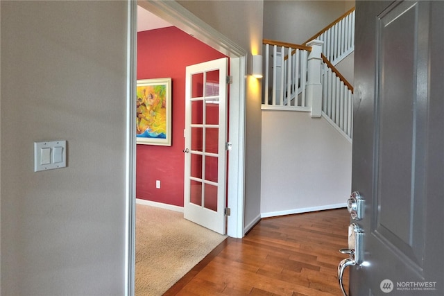 entrance foyer with baseboards, wood finished floors, and stairs