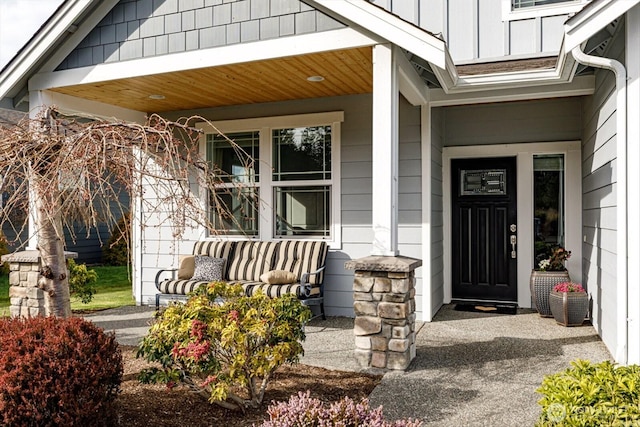 doorway to property featuring board and batten siding and covered porch
