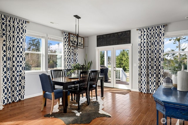 dining room featuring wood finished floors, french doors, baseboards, and visible vents