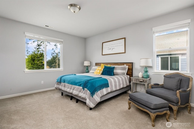 carpeted bedroom featuring baseboards and visible vents