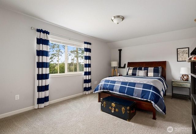 carpeted bedroom with lofted ceiling and baseboards