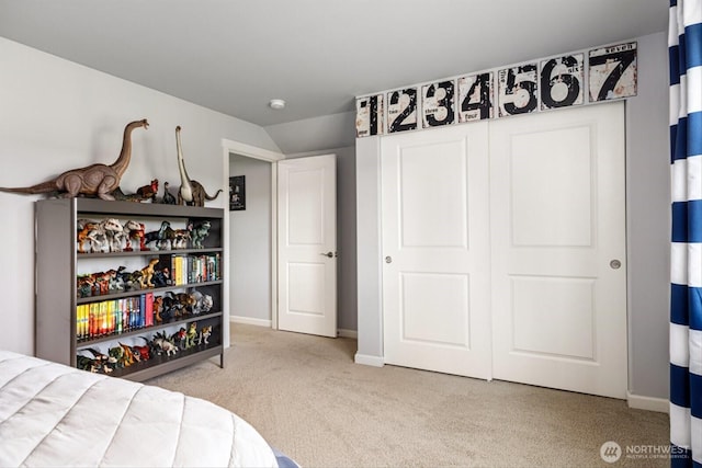 carpeted bedroom with baseboards and lofted ceiling