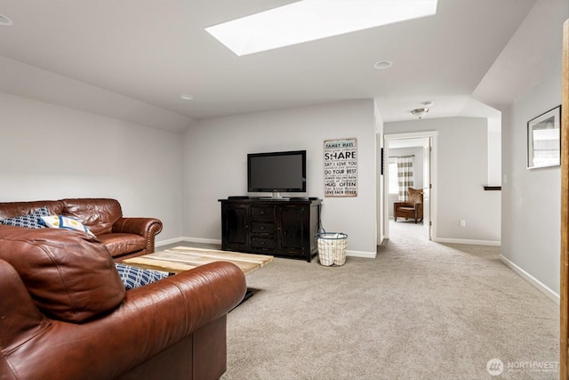 carpeted living room featuring baseboards and lofted ceiling with skylight