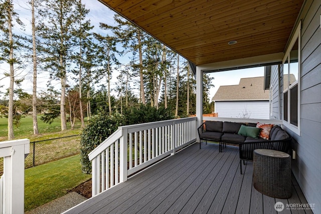 wooden terrace with a yard, an outdoor hangout area, and fence