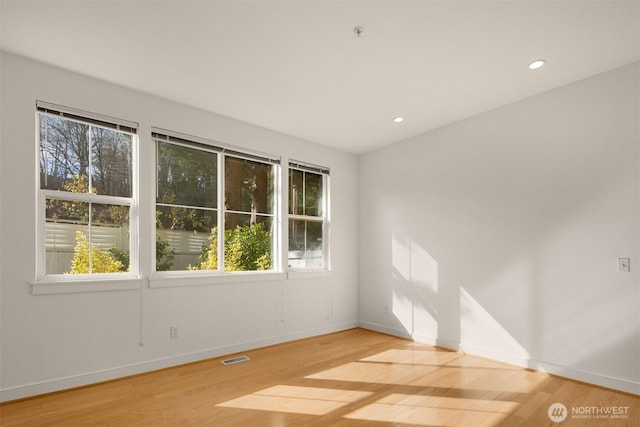 unfurnished room with baseboards, recessed lighting, visible vents, and light wood-style floors