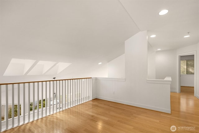 unfurnished room with baseboards, wood finished floors, and recessed lighting