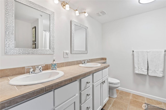 full bath featuring double vanity, visible vents, toilet, and a sink