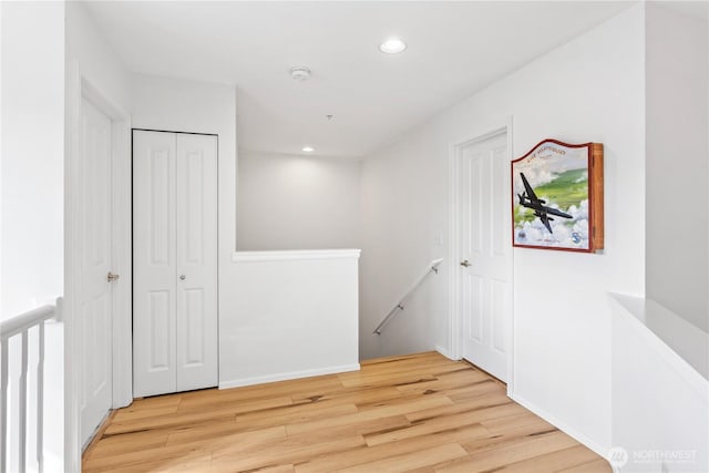 interior space with wood finished floors, an upstairs landing, and recessed lighting