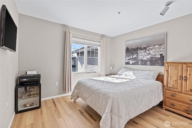 bedroom with light wood-style floors and baseboards