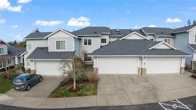 traditional home with driveway, roof with shingles, stone siding, and a residential view