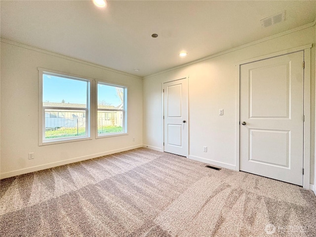 unfurnished bedroom featuring visible vents, ornamental molding, baseboards, and carpet floors