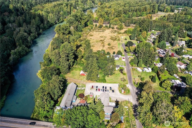 aerial view with a water view and a wooded view