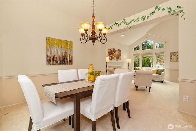 dining space featuring light colored carpet, a chandelier, and high vaulted ceiling