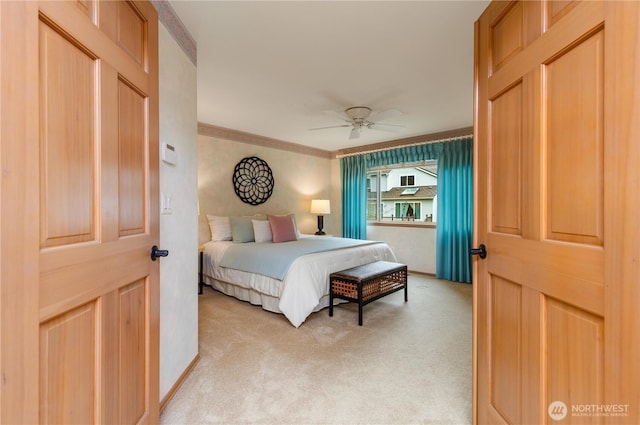 bedroom with light colored carpet, baseboards, crown molding, and ceiling fan