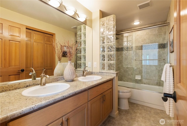 bathroom featuring double vanity, visible vents, toilet, and a sink