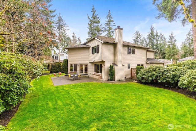 back of house with a patio area, a chimney, a yard, and fence