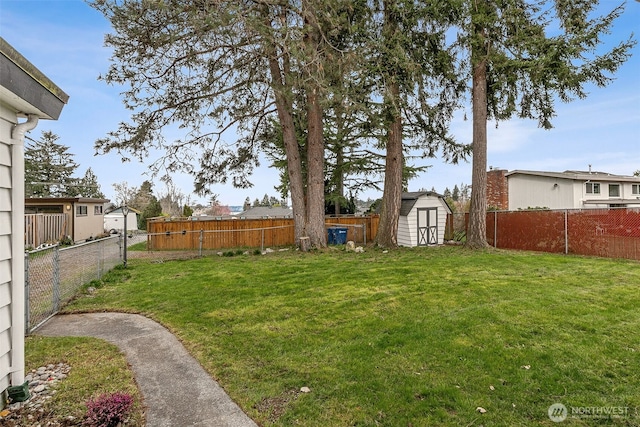 view of yard featuring an outbuilding, a storage unit, and a fenced backyard