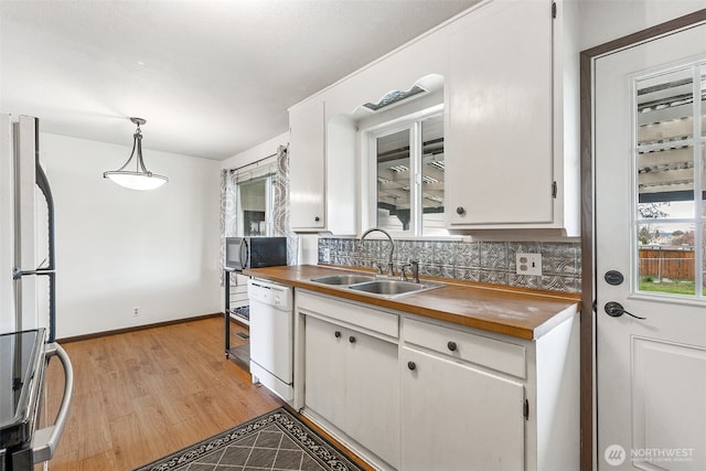 kitchen with pendant lighting, a sink, white cabinetry, white appliances, and decorative backsplash