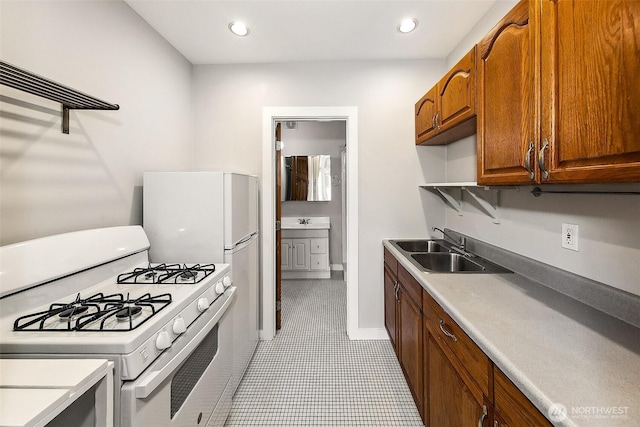 kitchen featuring gas range gas stove, open shelves, recessed lighting, light countertops, and a sink