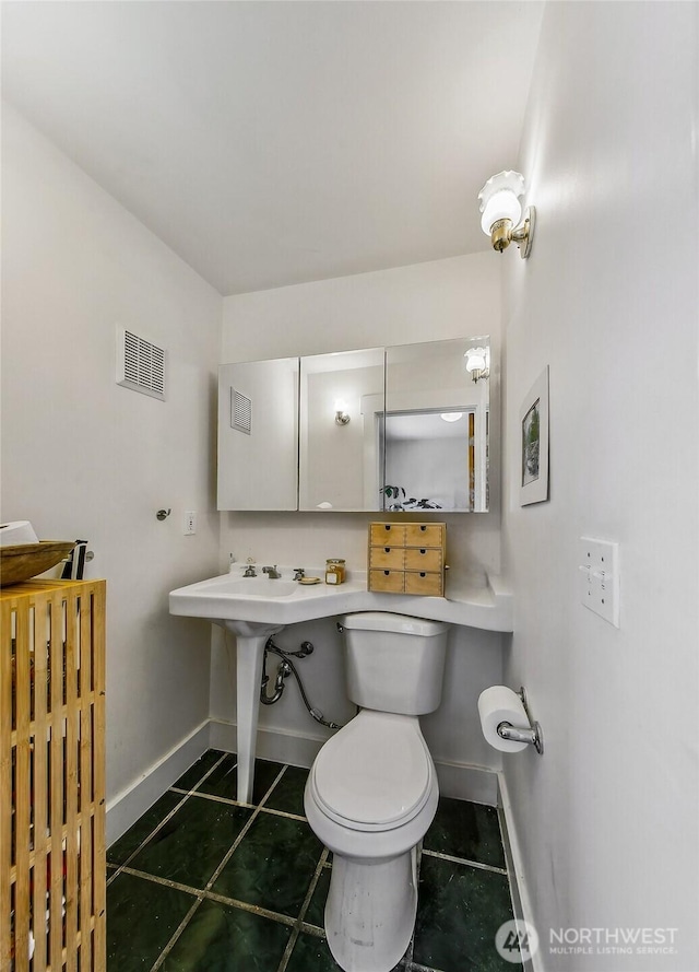 half bath with toilet, baseboards, visible vents, and tile patterned floors