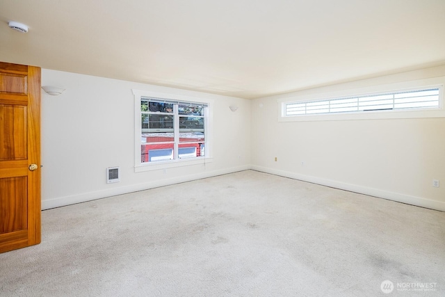 spare room featuring carpet, visible vents, and baseboards