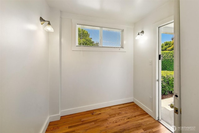 doorway to outside with light wood-type flooring and baseboards