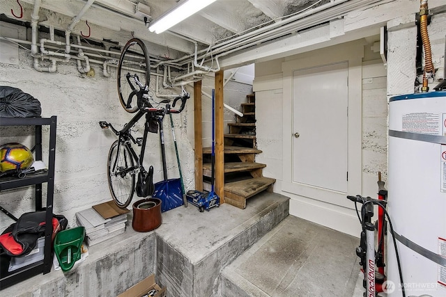 unfinished basement featuring secured water heater and stairway