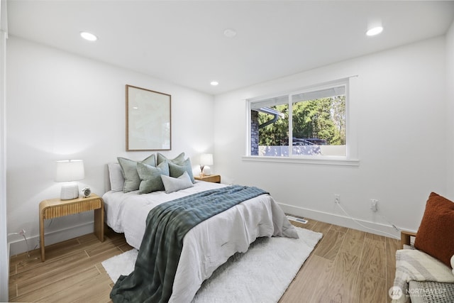 bedroom featuring baseboards, visible vents, wood finished floors, and recessed lighting