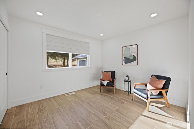 living area featuring recessed lighting, baseboards, visible vents, and light wood finished floors