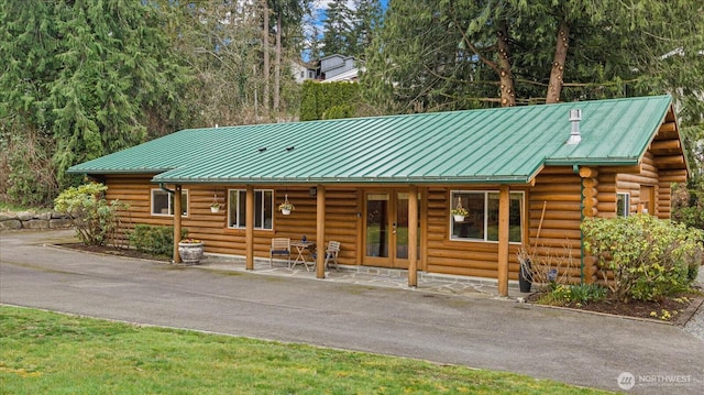 log cabin featuring log siding, metal roof, and a standing seam roof