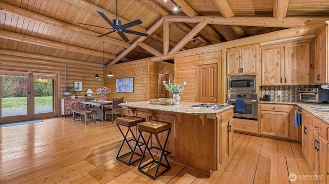 kitchen featuring beam ceiling, wood ceiling, appliances with stainless steel finishes, light wood-type flooring, and a center island